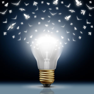 Creative start concept as a bright illuminated light bulb transforming to white flying birds as a digital messaging metaphor and social media creativity and distribution of innovative new ideas.